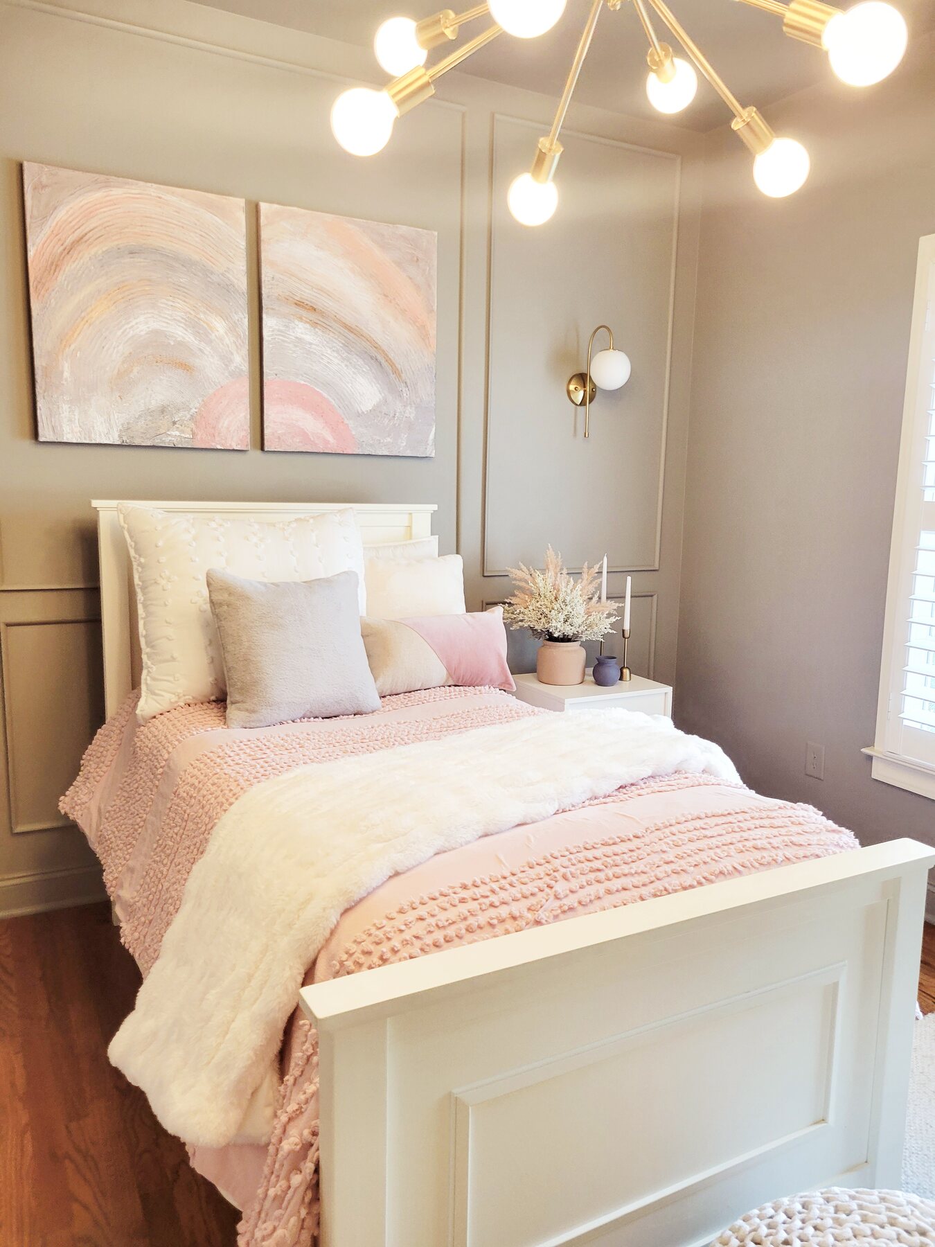 Light bedroom with layered ivory bedding and subtle blush accents